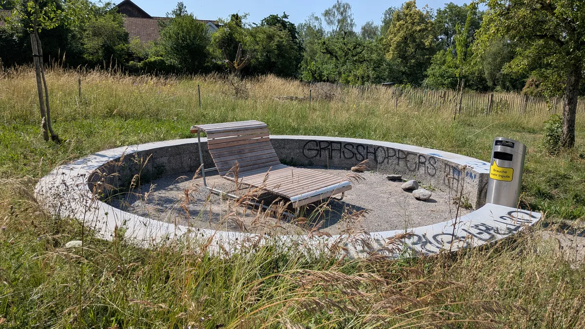 Die Lümmelecke mit Abfallkübel und Markierungen von Fussballanhängern. Impressionen aus einem Park.